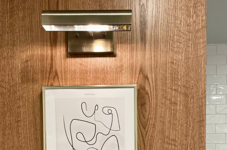 Réalisation résidentiel avec luminaire or dans la salle de bain.